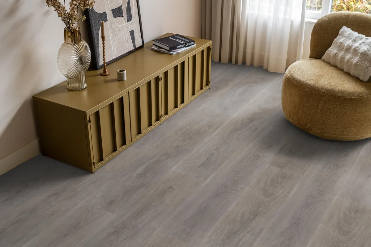 Parramatta / Robusto Grey oak, klik pvc in een woonkamer, met een okergeel dressoir en een ronde fauteuil
