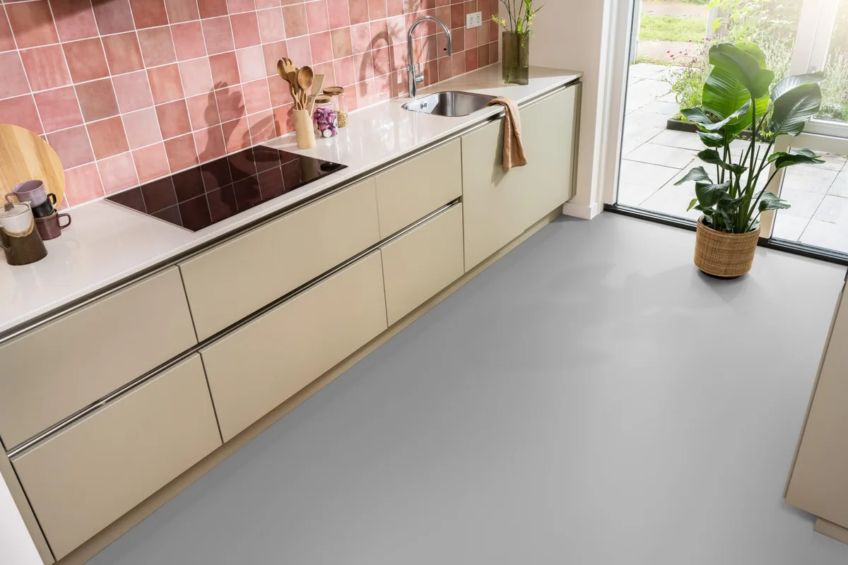 YUP / Spigato Grey, visgraat klik pvc in een keuken met een roze tegelwand en openslaande tuindeuren