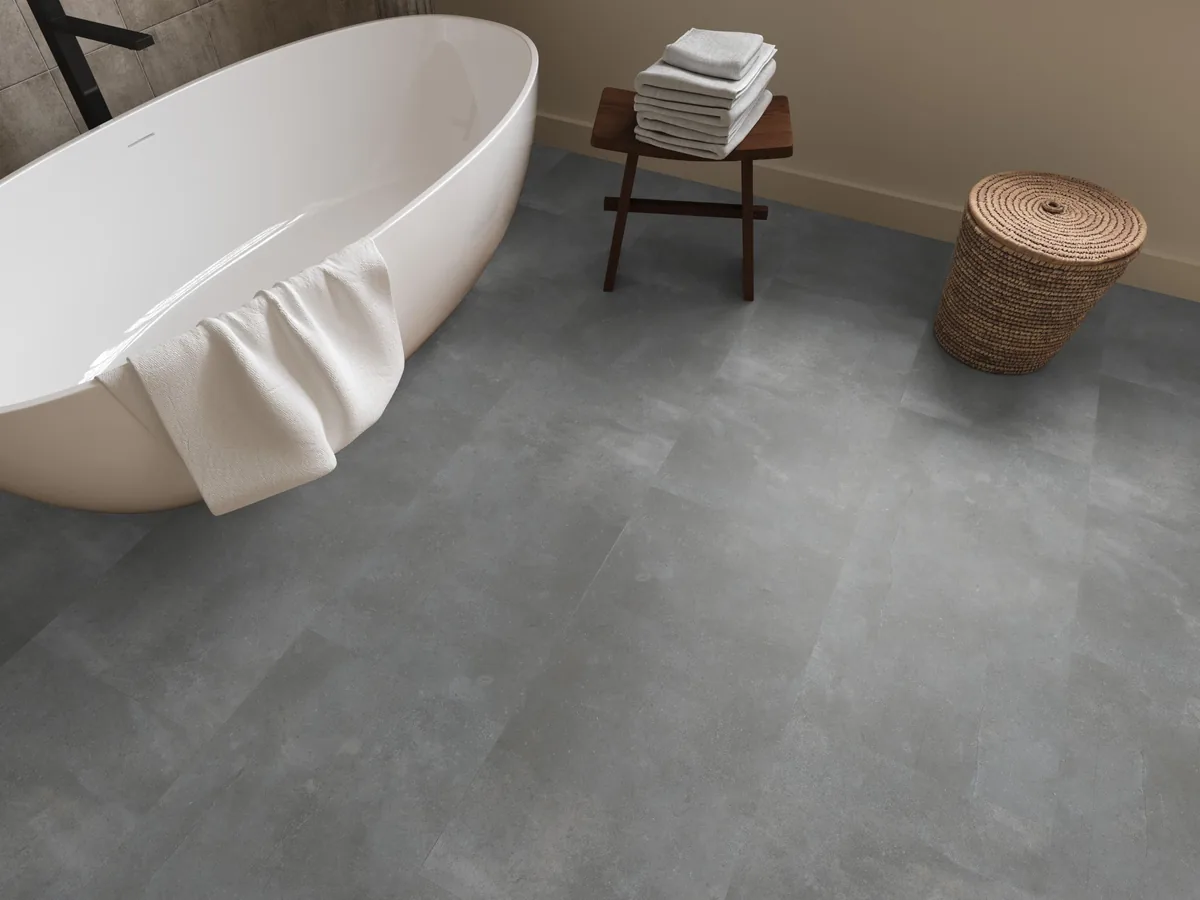 Ealing / Piazzo grey, klik pvc in een badkamer, met een vrijstaand bad en een rieten wasmand