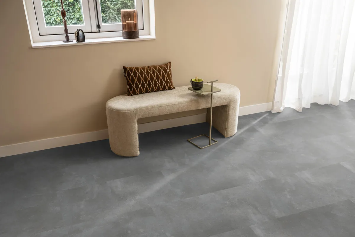 Ealing / Piazzo grey, klik pvc in een hal, met een bankje onder het raam en zonlicht over de vloer