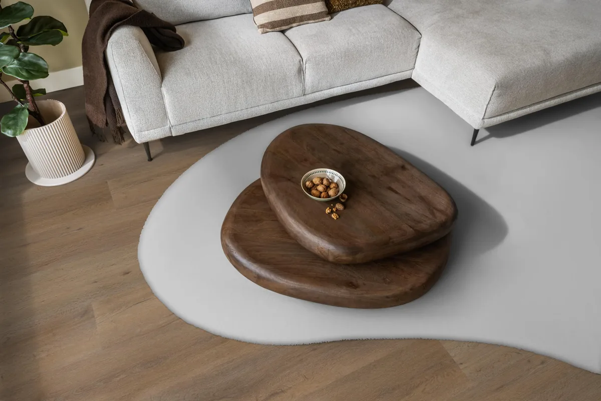 Leyton / Vivero smoky, klik pvc in een woonkamer, met een lichte hoekbank en een wit vloerkleed