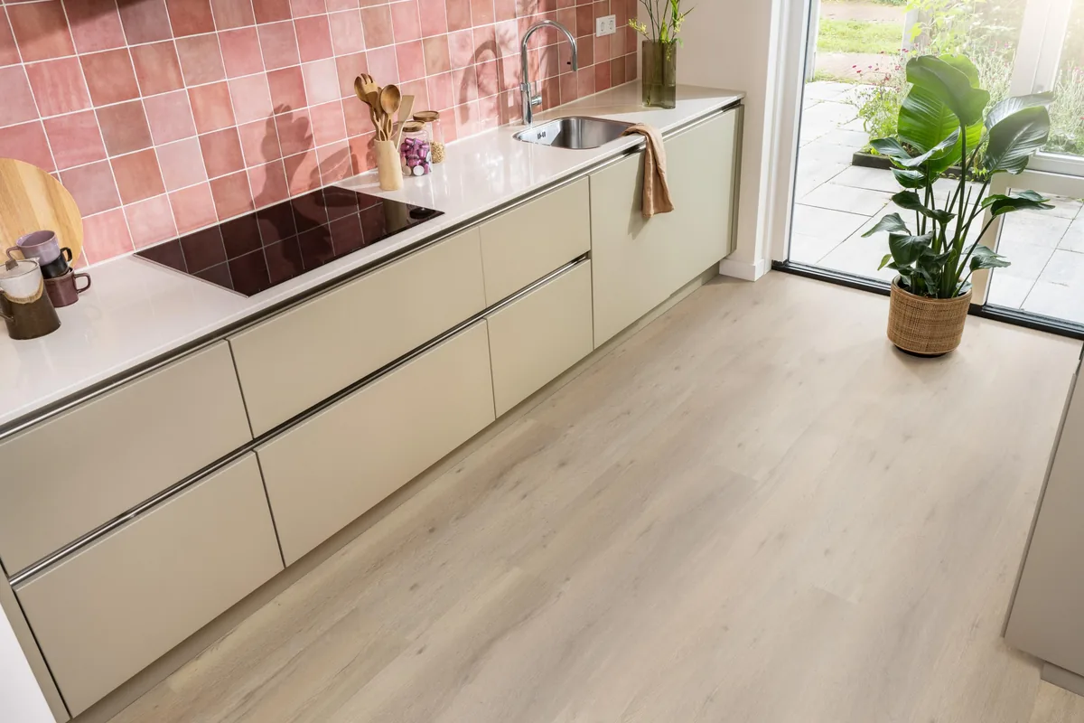 Leyton / Vivero natural oak, klik pvc in een keuken met een roze tegelwand en openslaande tuindeuren