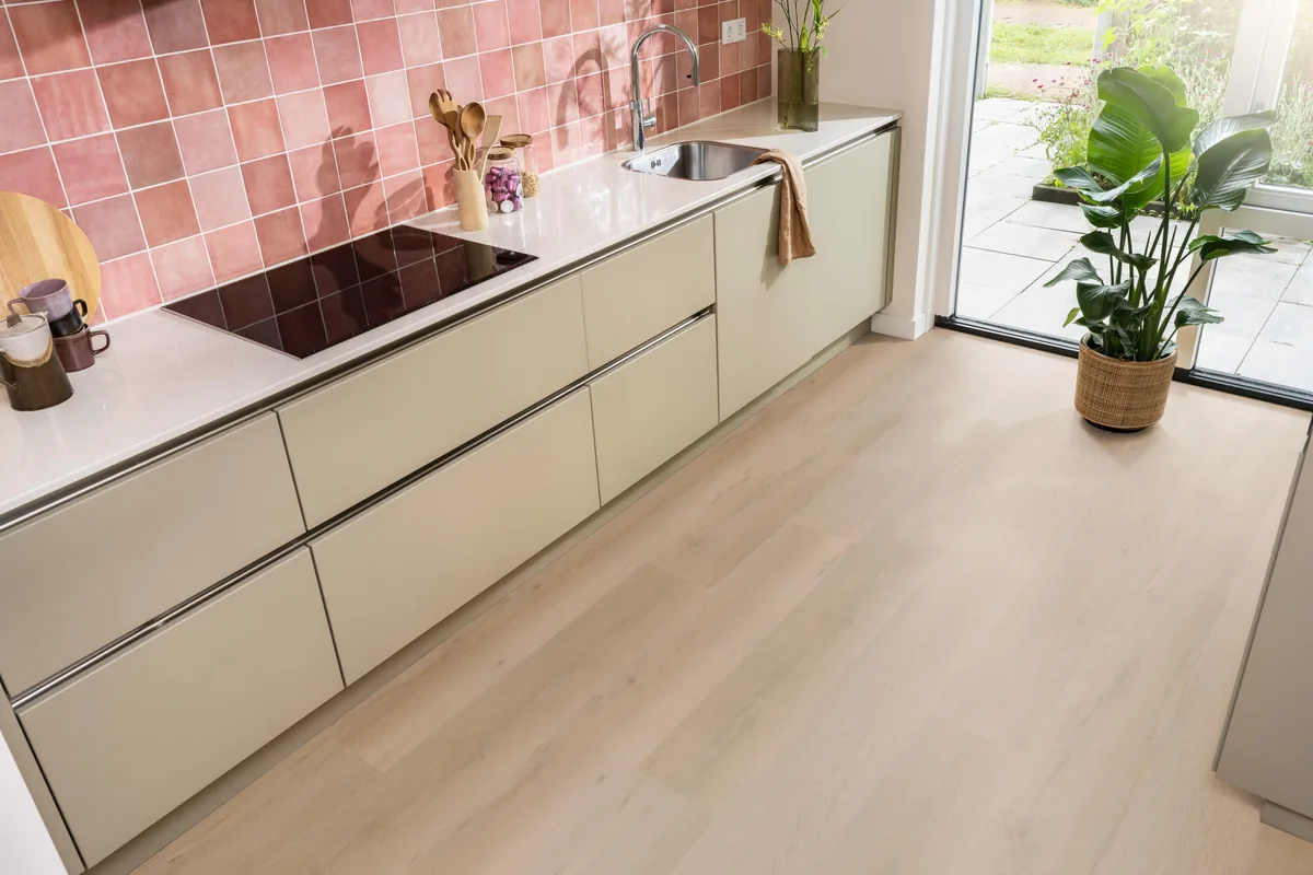 Leyton / Vivero warm oak, klik pvc in een keuken met een roze tegelwand en openslaande tuindeuren