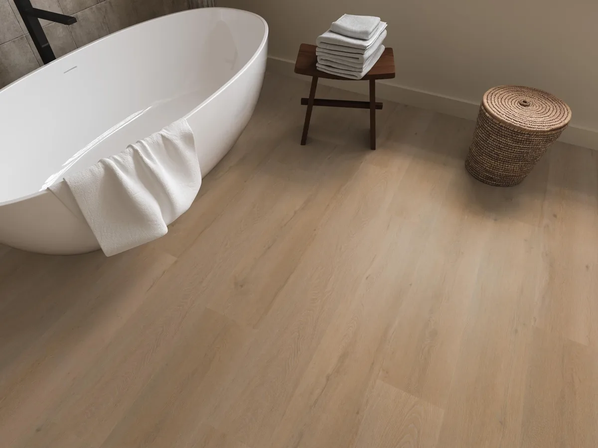 Leyton / Vivero warm oak, klik pvc in een badkamer, met een vrijstaand bad en een rieten wasmand