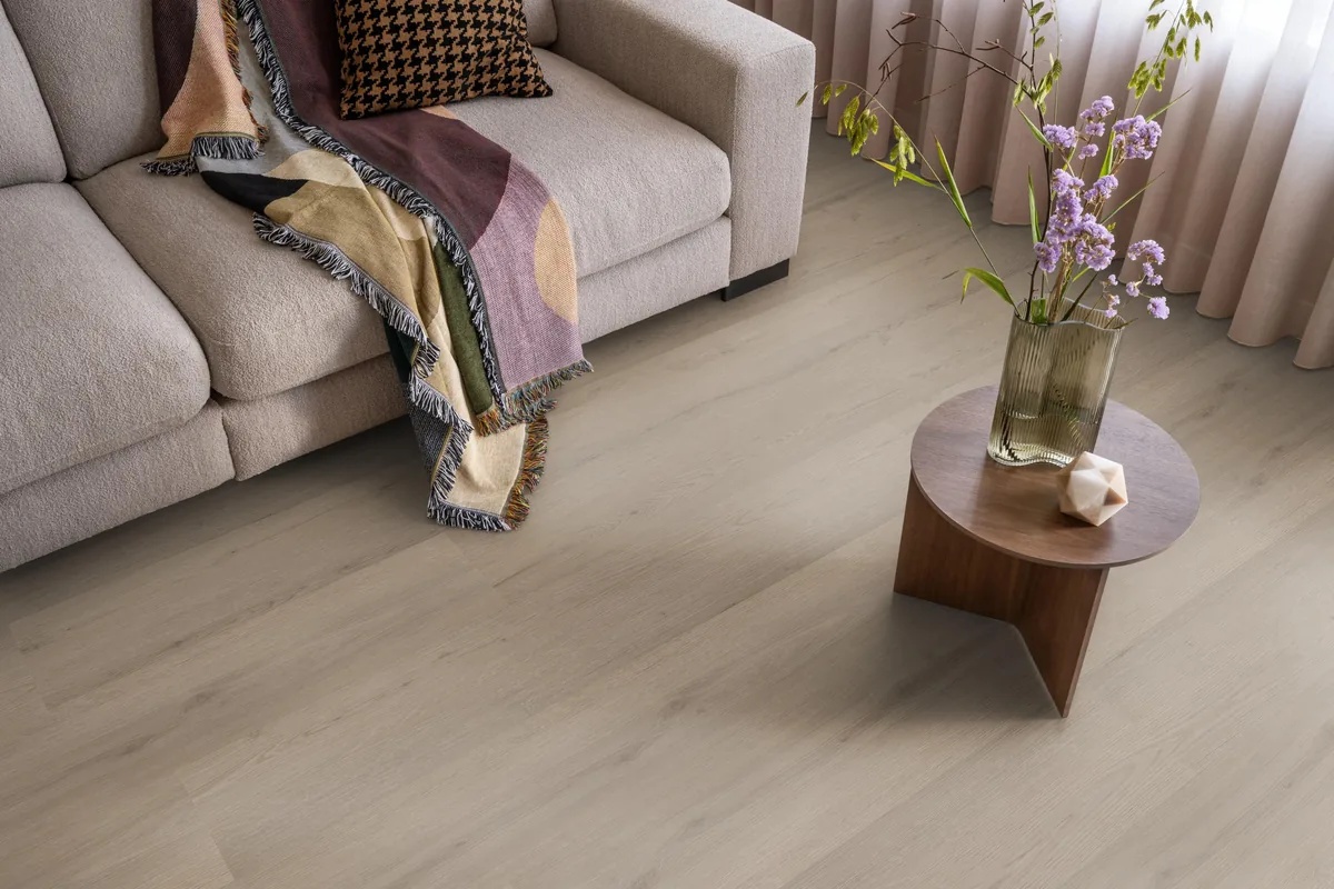 Barnet / Venera smoky, plak pvc in een woonkamer, met een beige bank en een ronde bijzettafel met bloemen
