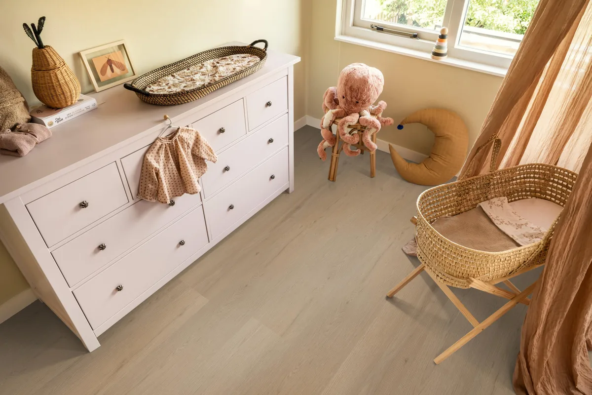 Barnet / Venera natural oak, plak pvc in een babykamer, met een witte commode en een rieten wieg