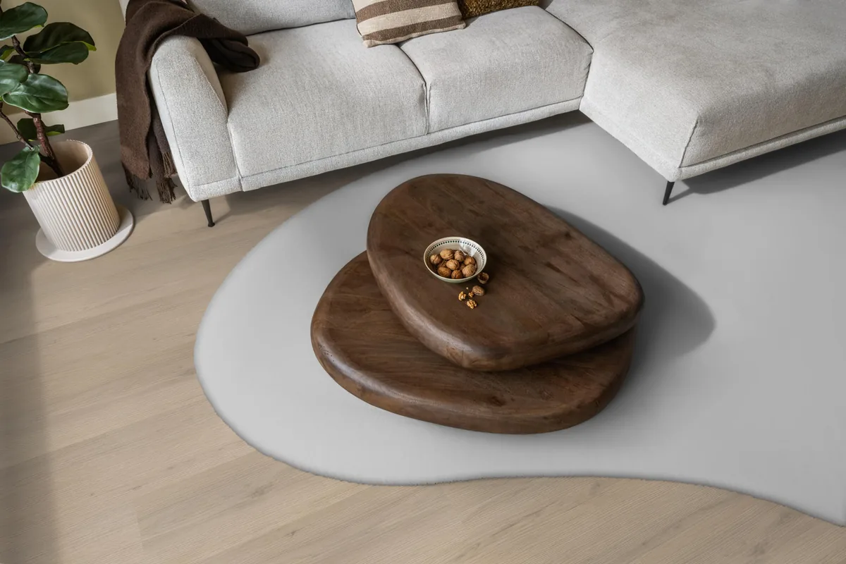 Barnet / Venera Beige, klik pvc in een woonkamer, met een lichte hoekbank en een wit vloerkleed