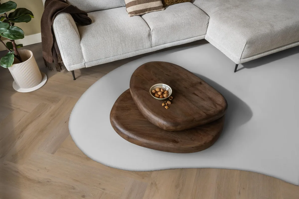 Leyton / Vivero natural oak, visgraat plak pvc in een woonkamer, met een lichte hoekbank en een wit vloerkleed