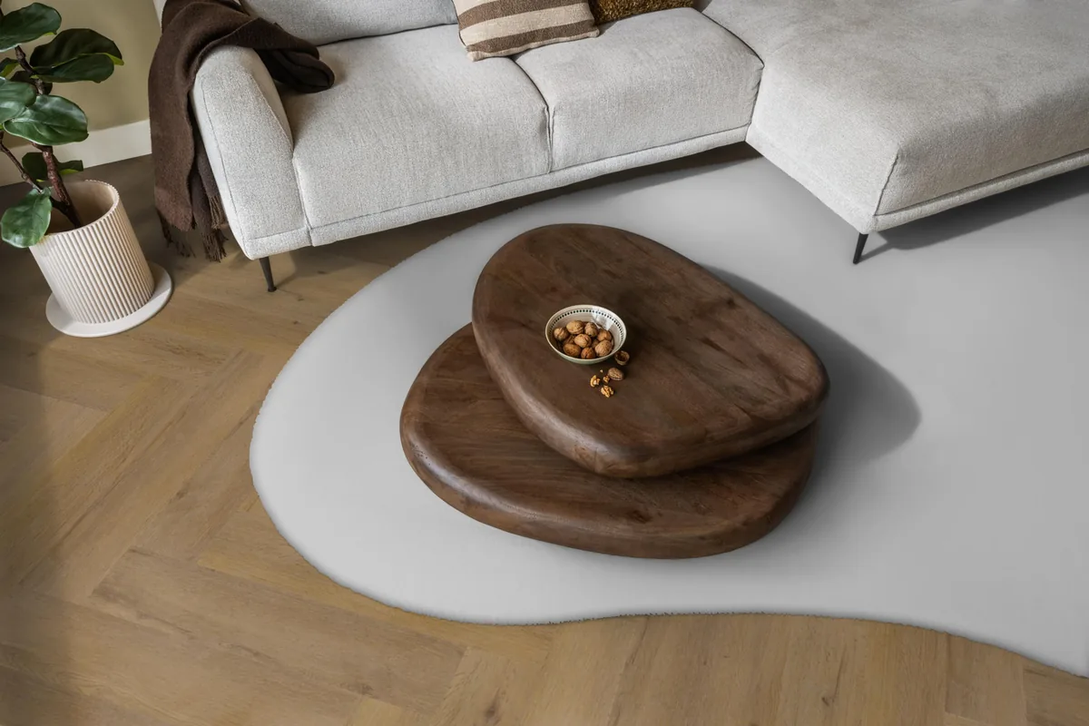 Leyton / Vivero dark oak, visgraat plak pvc in een woonkamer, met een lichte hoekbank en een wit vloerkleed
