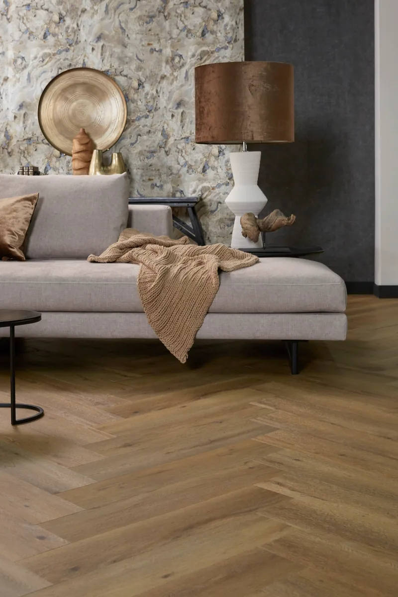 Leyton / Vivero dark oak, visgraat plak pvc in een woonkamer, met een witte kastenwand en een lichte poef
