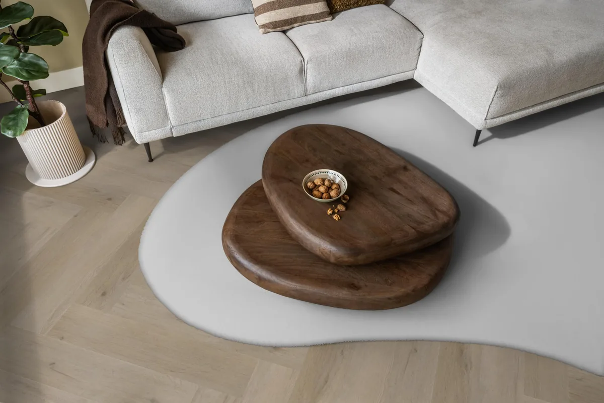 Leyton / Vivero Light oak, visgraat klik pvc in een woonkamer, met een lichte hoekbank en een wit vloerkleed