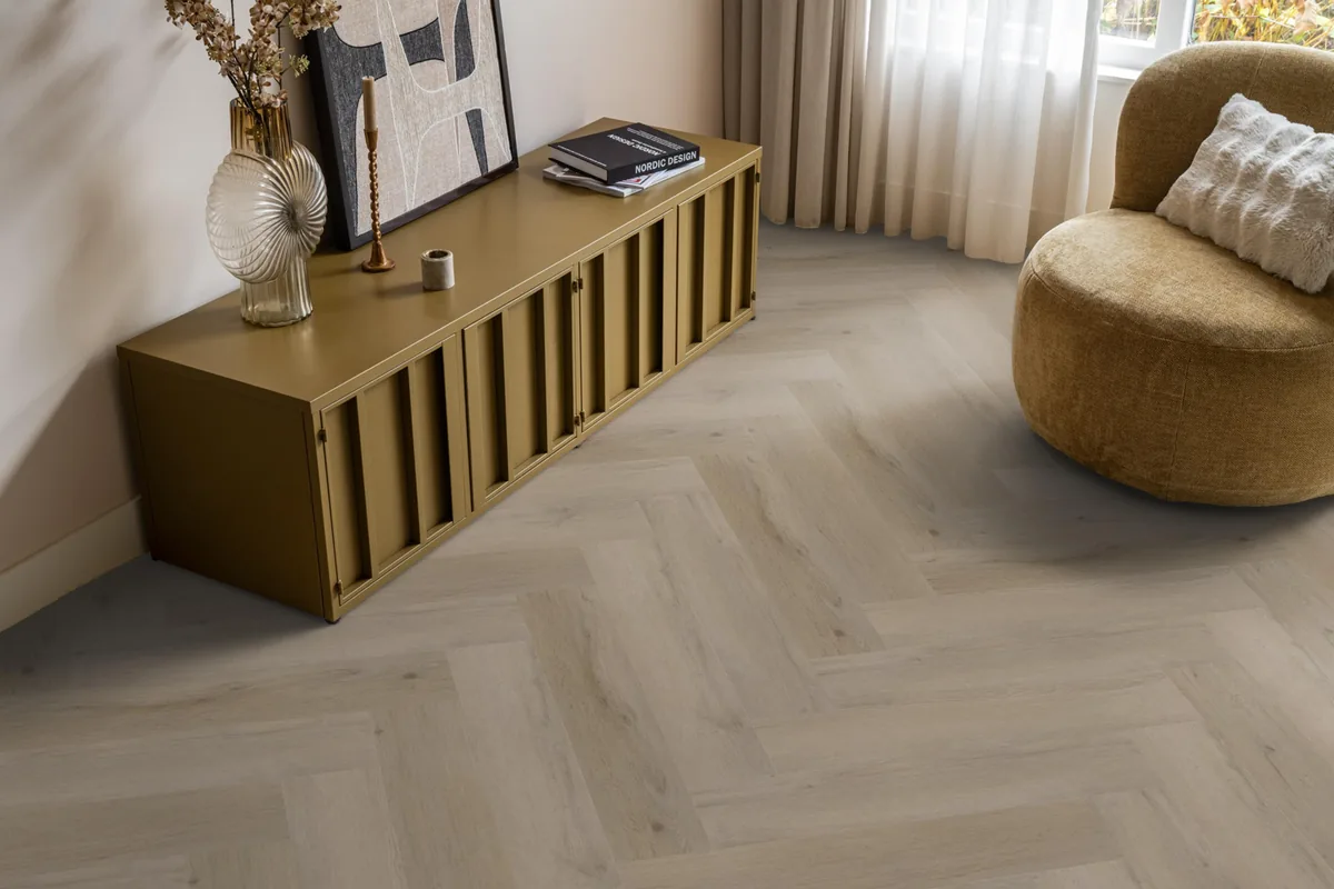 Leyton / Vivero Light oak, visgraat klik pvc in een woonkamer, met een okergeel dressoir en een ronde fauteuil