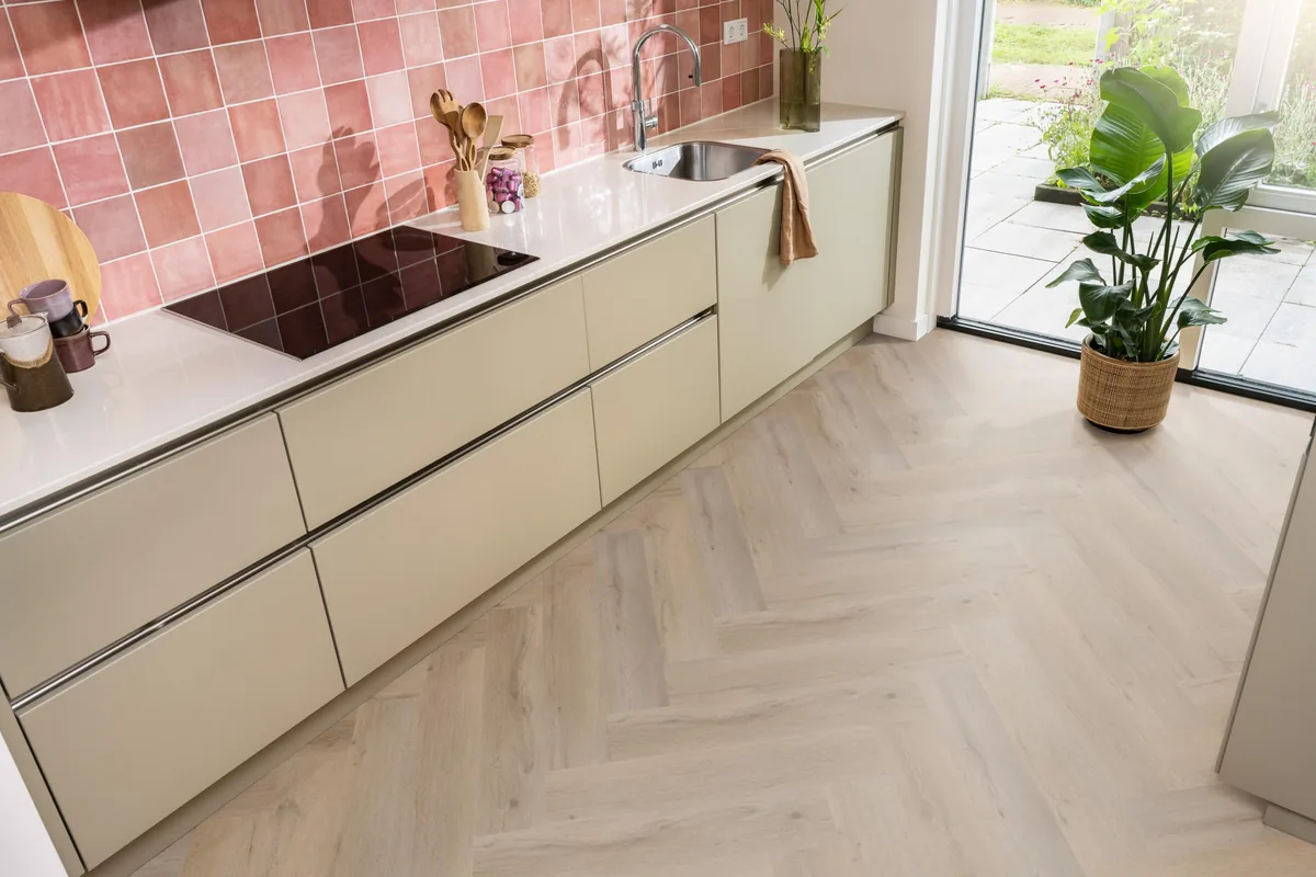 Leyton / Vivero Smoky, visgraat klik pvc in een keuken met een roze tegelwand en openslaande tuindeuren
