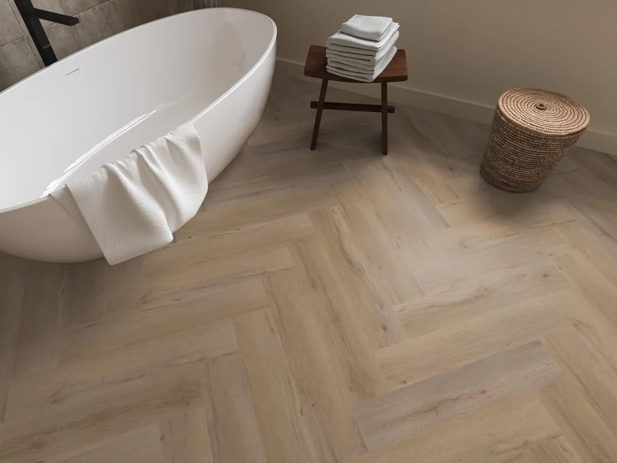 Leyton / Vivero Smoky, visgraat klik pvc in een badkamer, met een vrijstaand bad en een rieten wasmand