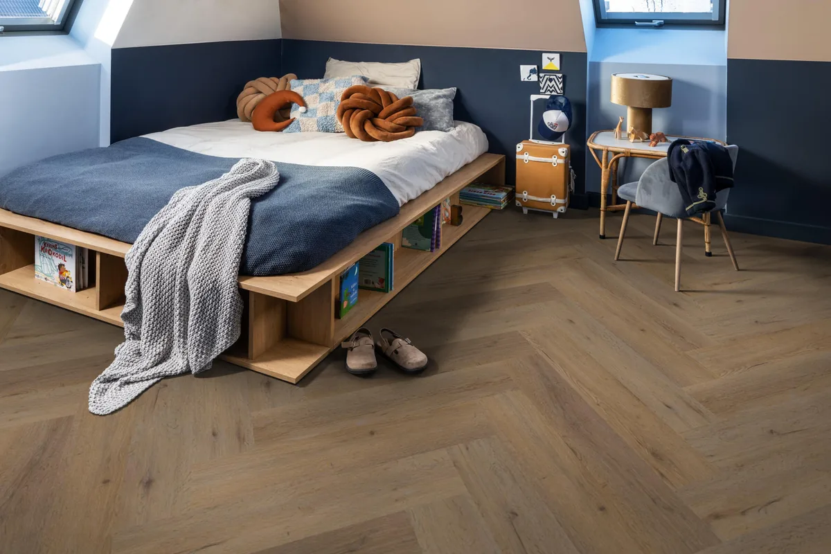 Leyton / Vivero Natural oak, visgraat klik pvc in een slaapkamer onder een schuin dak, met een houten bedombouw en sloffen ervoor