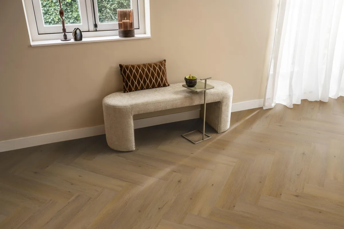 Leyton / Vivero Dark oak, visgraat klik pvc in een hal, met een bankje onder het raam en zonlicht over de vloer