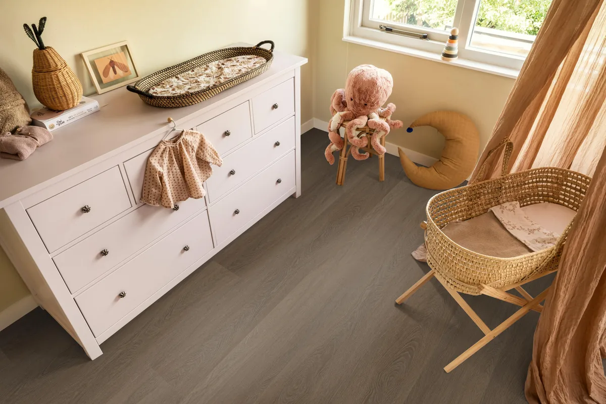 Fulham / Estino brown, plak pvc in een babykamer, met een witte commode en een rieten wieg