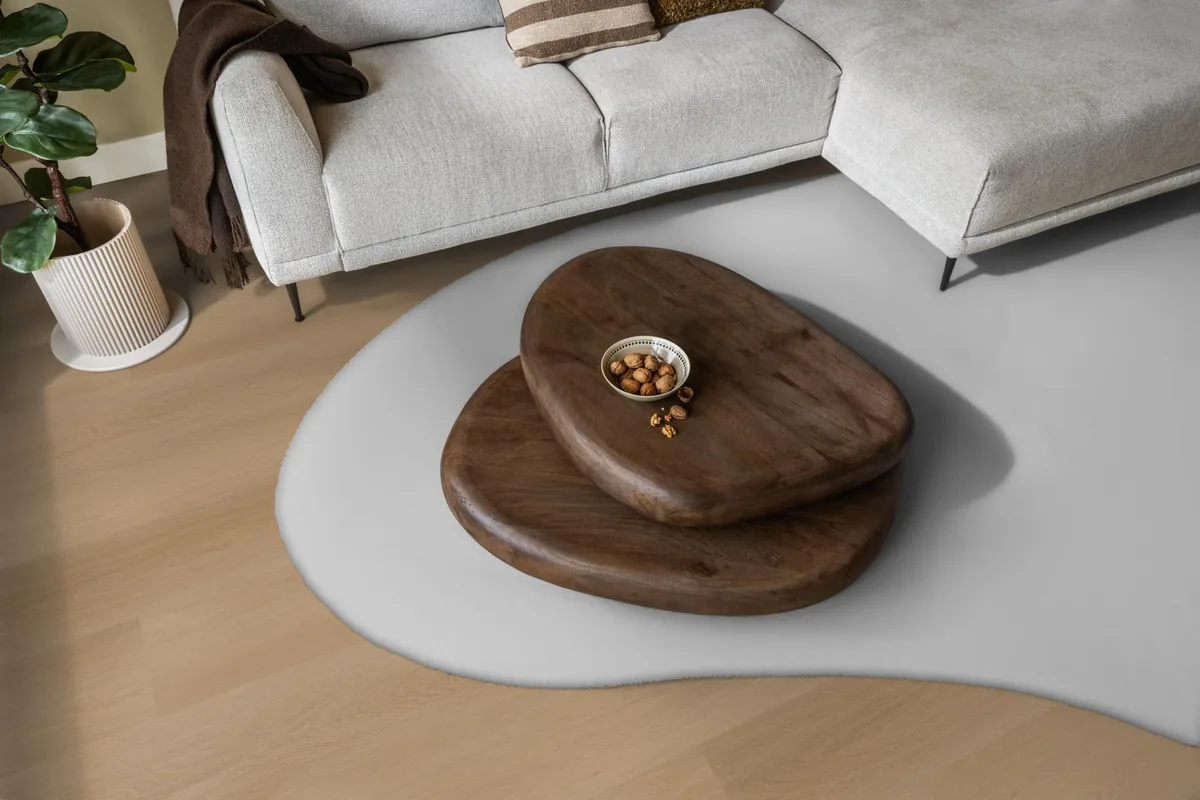 Fulham / Estino dark oak, klik pvc in een woonkamer, met een lichte hoekbank en een wit vloerkleed