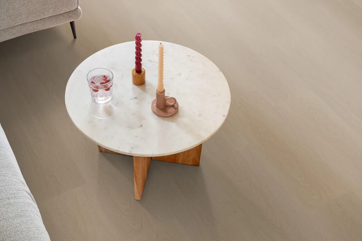 Fulham / Estino smoky, klik pvc in een woonkamer, met een ronde marmeren salontafel en twee kaarsen