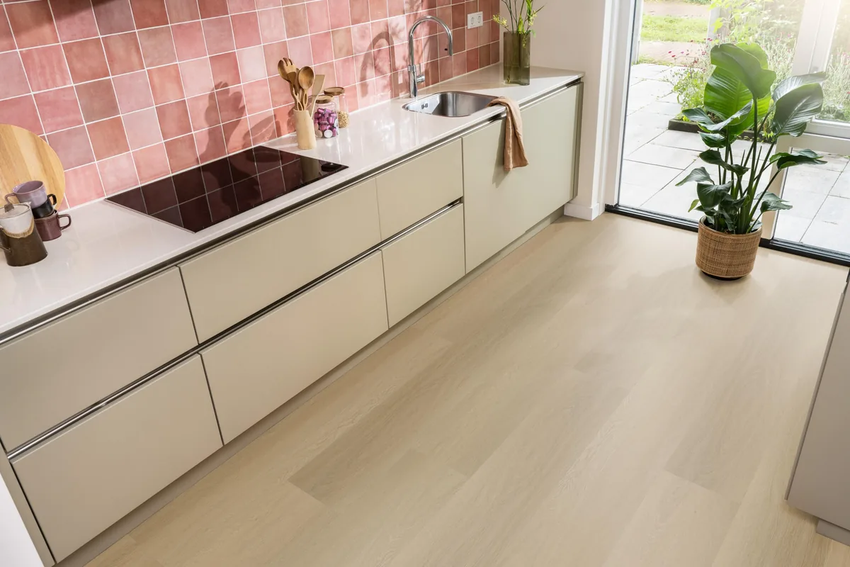 Fulham / Estino warm oak, klik pvc in een keuken met een roze tegelwand en openslaande tuindeuren