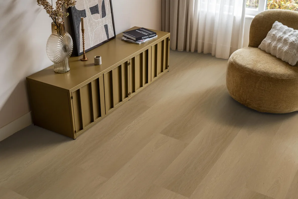 Fulham / Estino warm oak, klik pvc in een woonkamer, met een okergeel dressoir en een ronde fauteuil