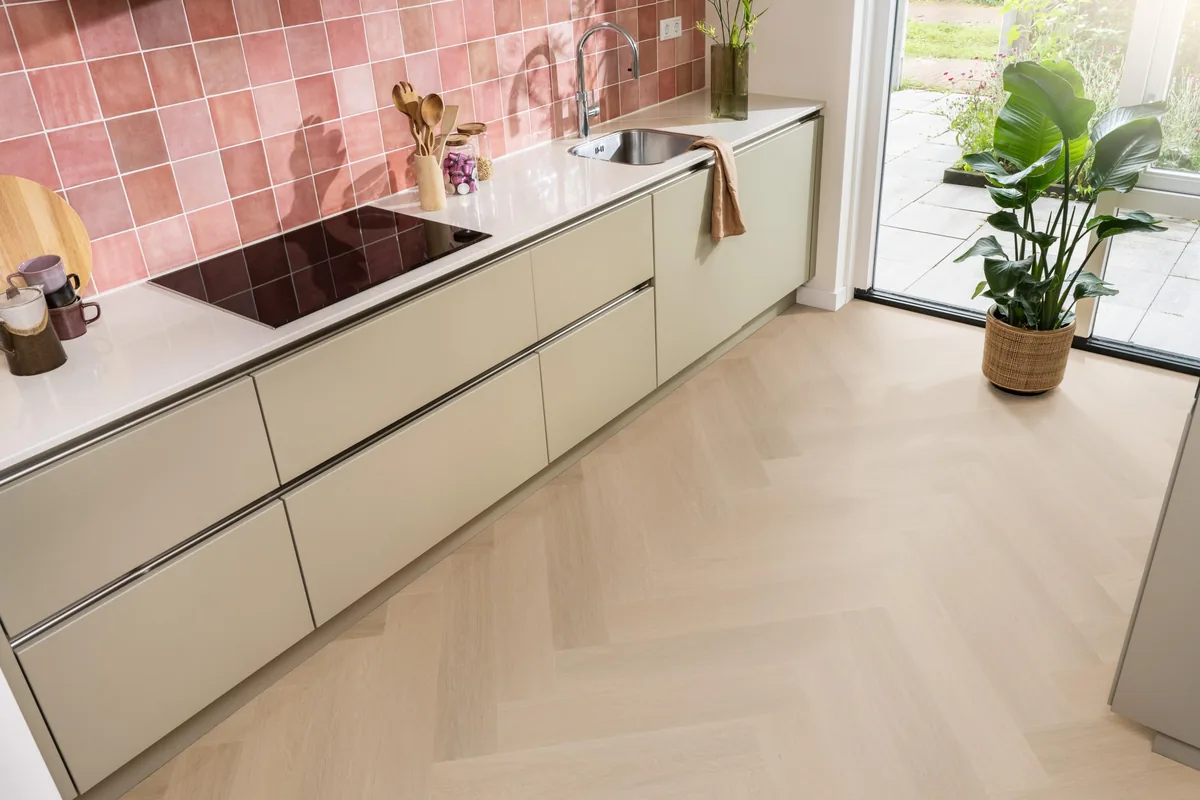 Fulham / Estino dark oak, visgraat plak pvc in een keuken met een roze tegelwand en openslaande tuindeuren