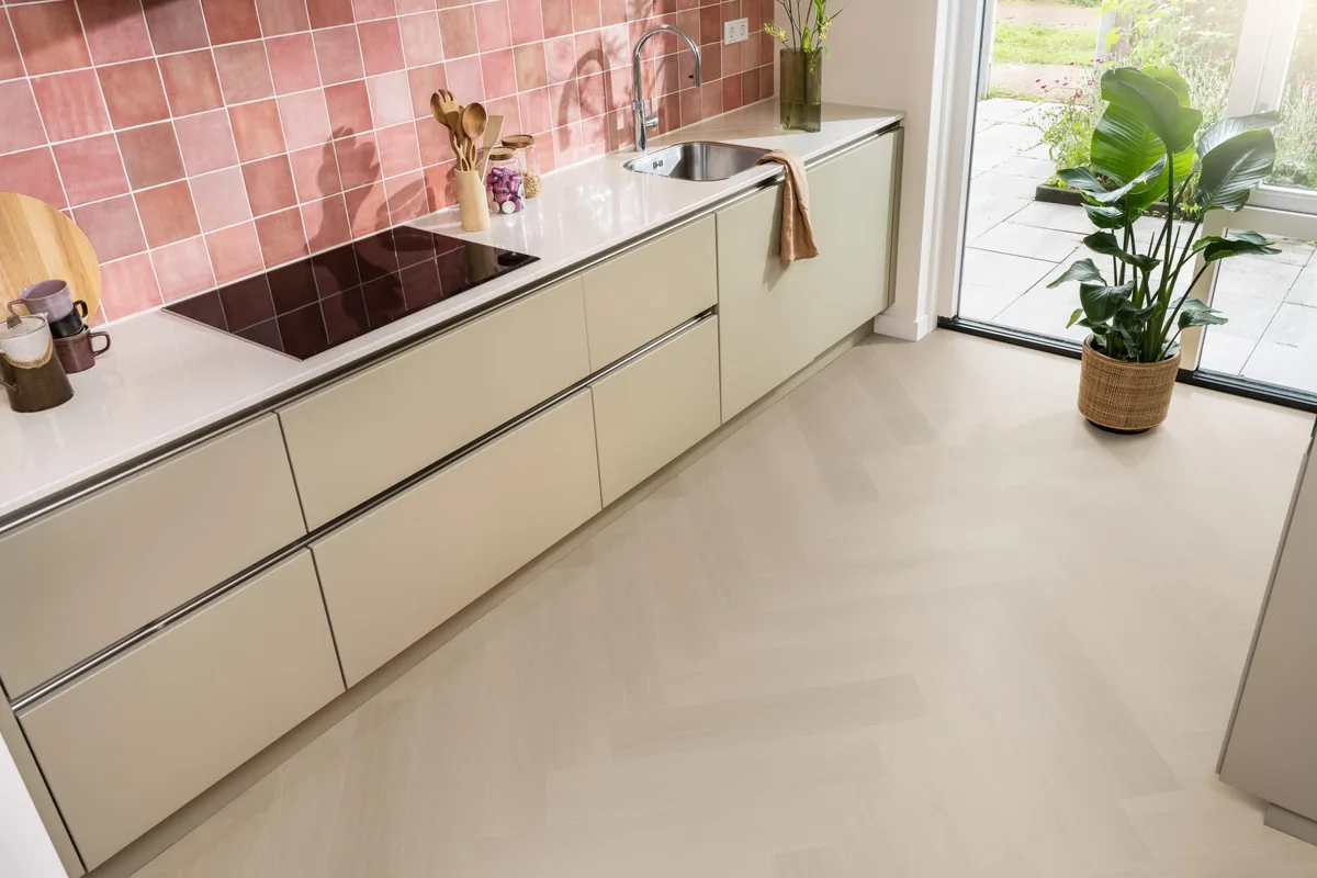 Fulham / Estino smoky, visgraat plak pvc in een keuken met een roze tegelwand en openslaande tuindeuren