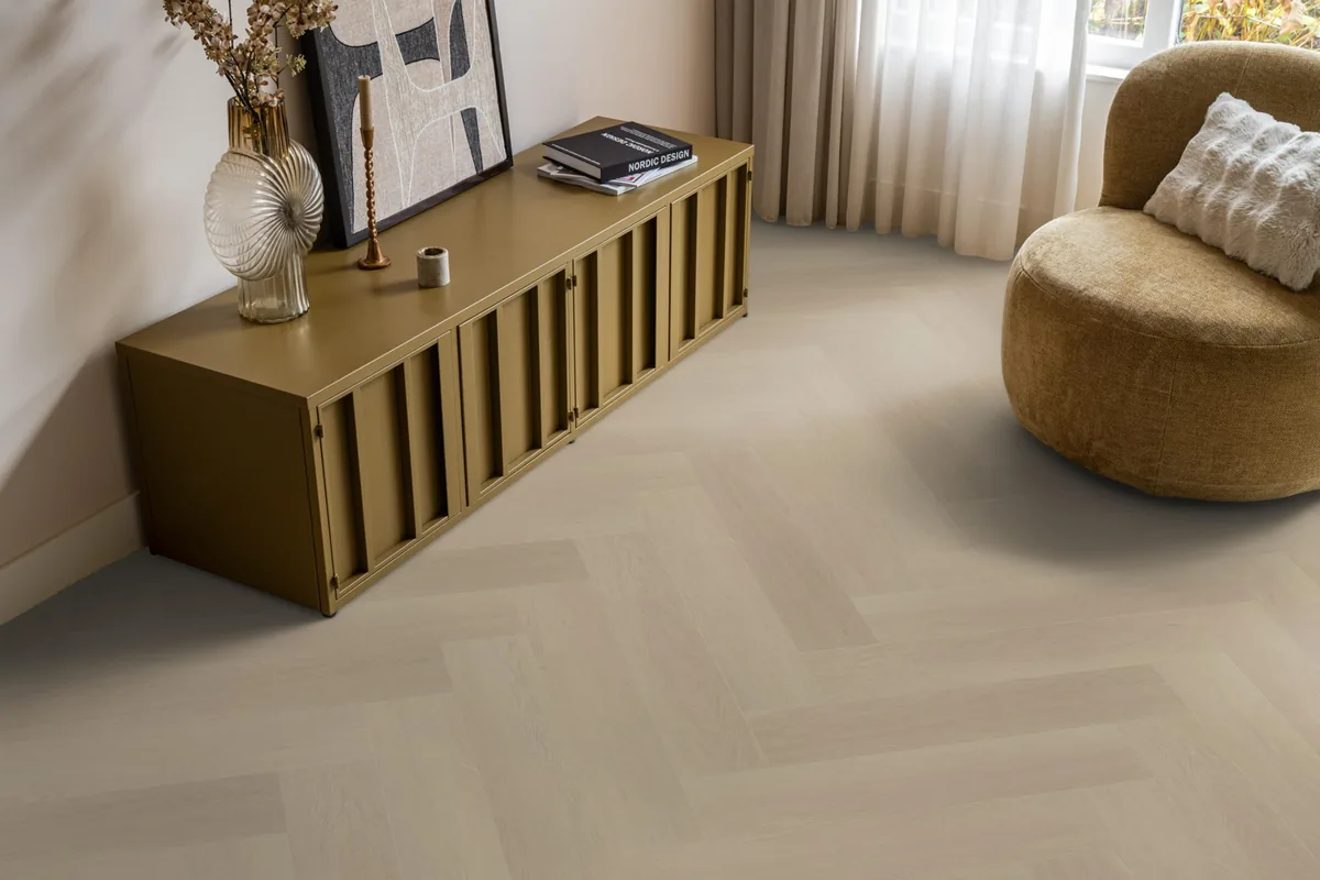 Fulham / Estino beige, visgraat plak pvc in een woonkamer, met een okergeel dressoir en een ronde fauteuil