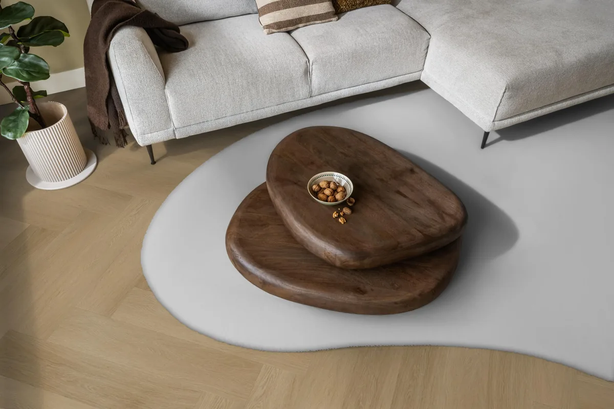 Fulham / Estino warm oak, visgraat plak pvc in een woonkamer, met een lichte hoekbank en een wit vloerkleed