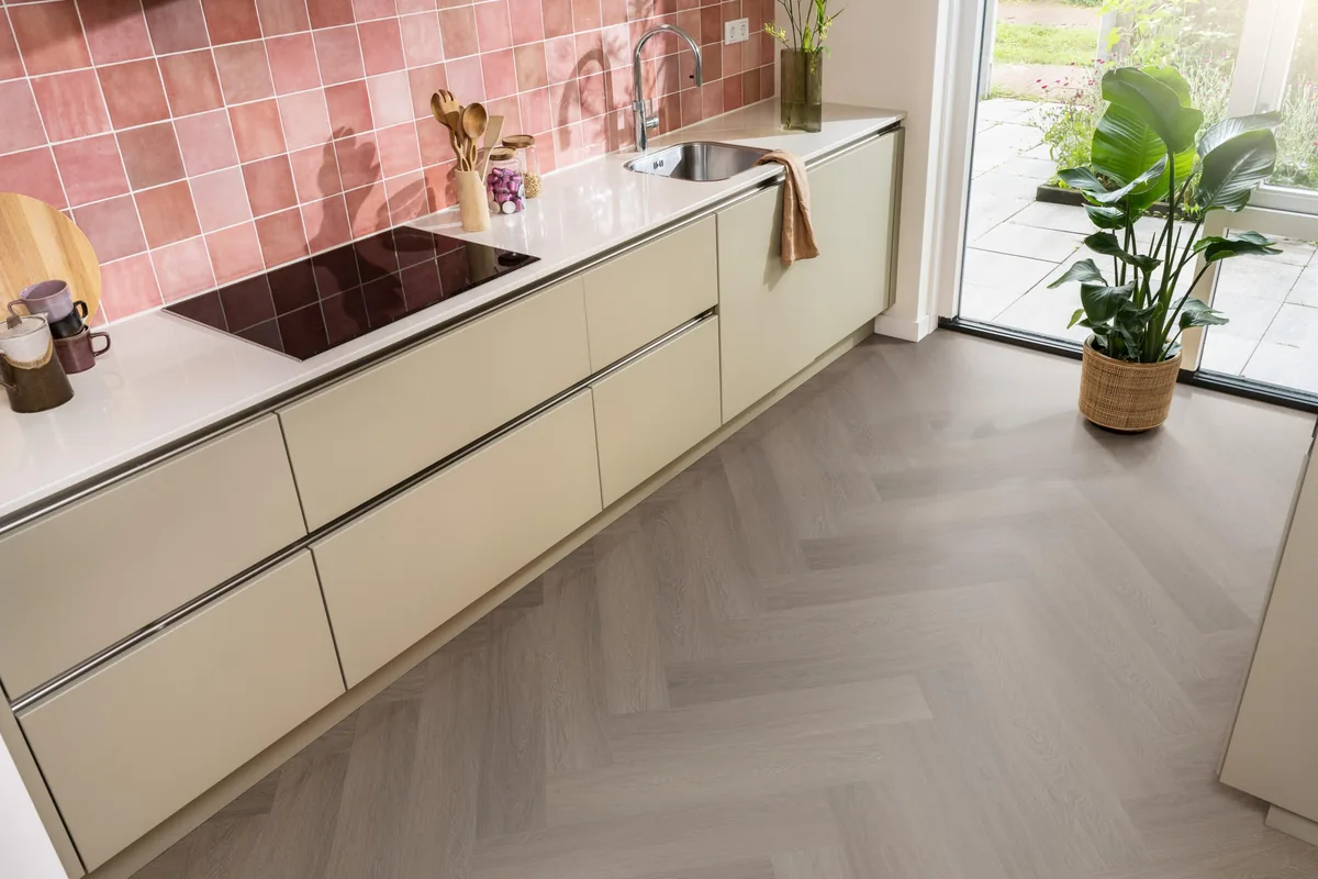 Fulham / Estino brown, visgraat plak pvc in een keuken met een roze tegelwand en openslaande tuindeuren