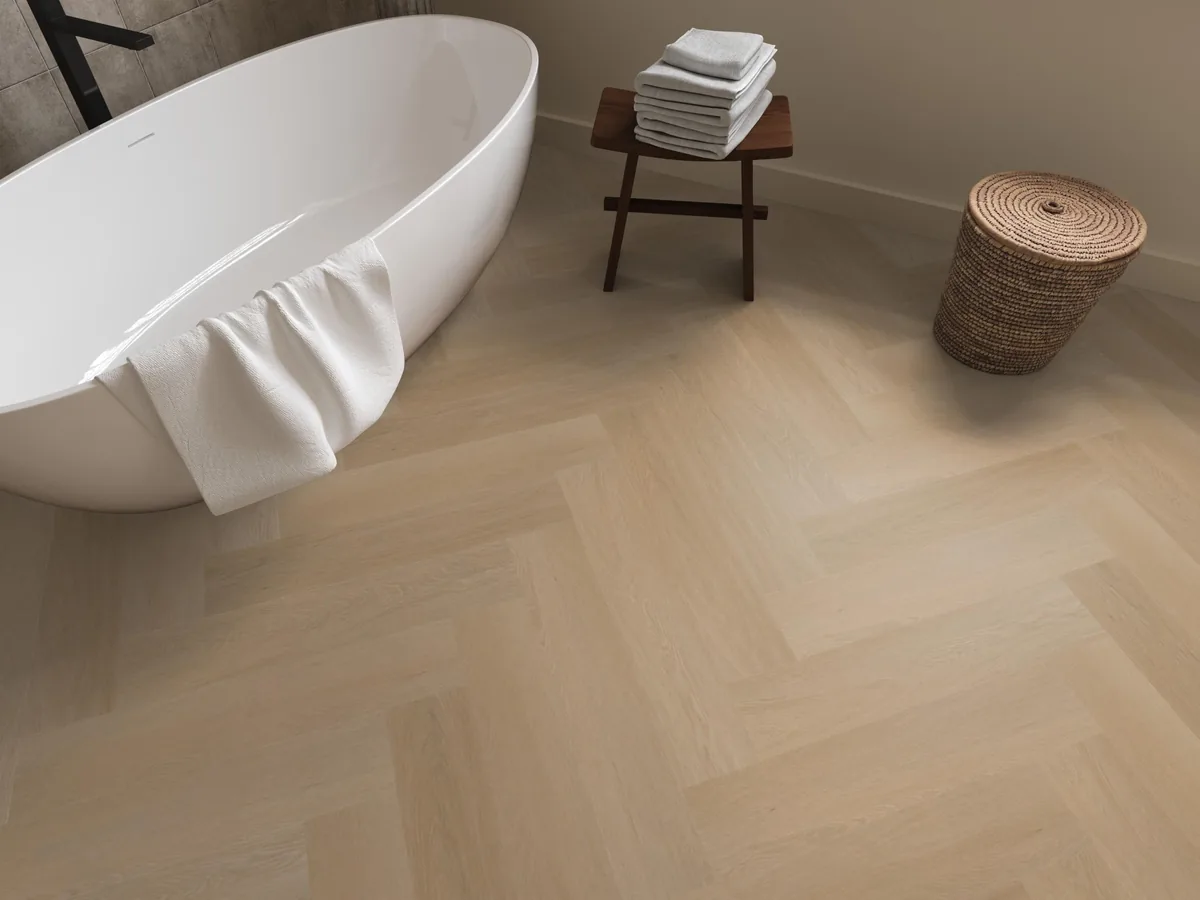 Fulham / Estino Natural oak, visgraat klik pvc in een badkamer, met een vrijstaand bad en een rieten wasmand