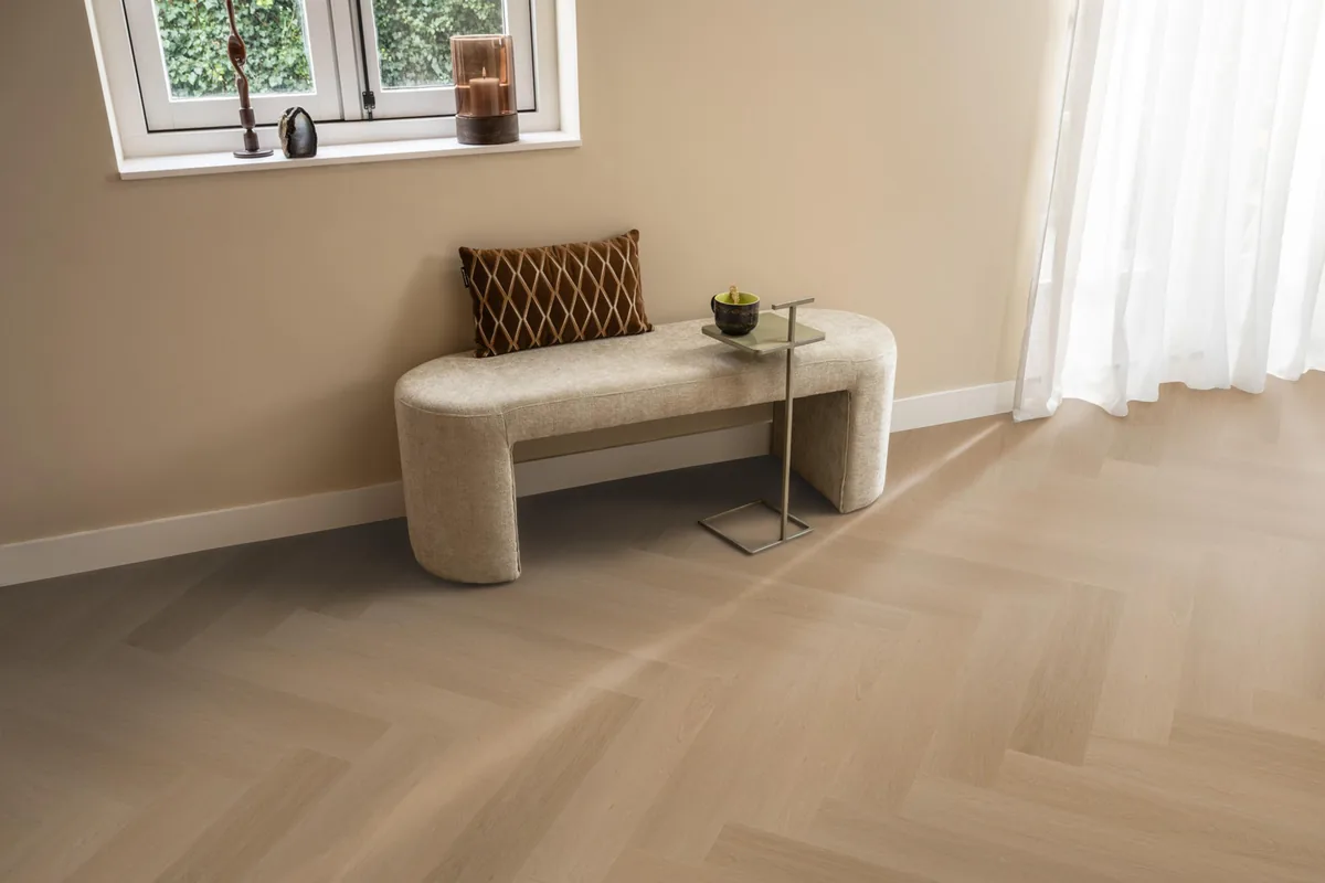 Fulham / Estino Dark oak, visgraat klik pvc in een hal, met een bankje onder het raam en zonlicht over de vloer