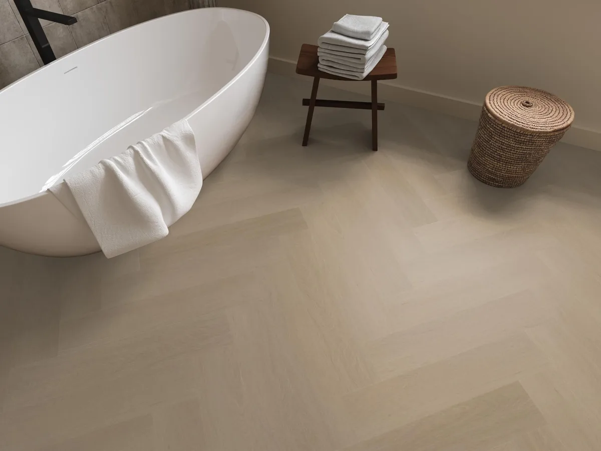 Fulham / Estino Smoky, visgraat klik pvc in een badkamer, met een vrijstaand bad en een rieten wasmand