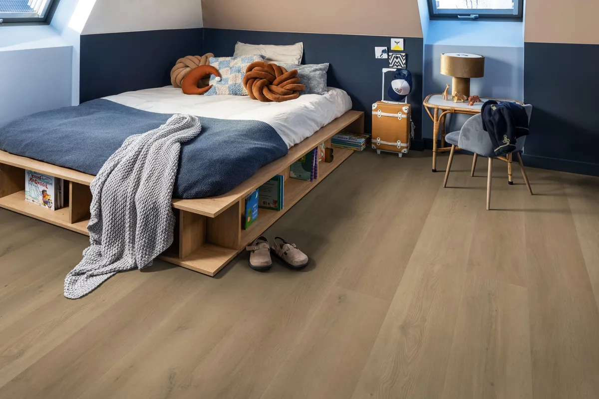 Greenwich / Espero warm oak, plak pvc in een slaapkamer onder een schuin dak, met een houten bedombouw en sloffen ervoor