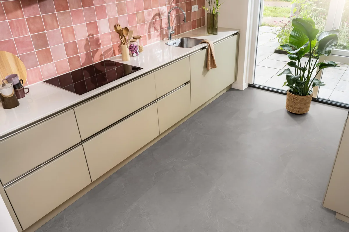 Stanmore / Noveno dark grey, plak pvc in een keuken met een roze tegelwand en openslaande tuindeuren