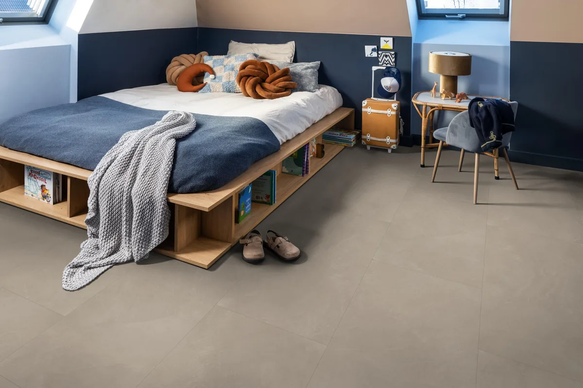 Stanmore / Noveno warm beige, plak pvc in een slaapkamer onder een schuin dak, met een houten bedombouw en sloffen ervoor