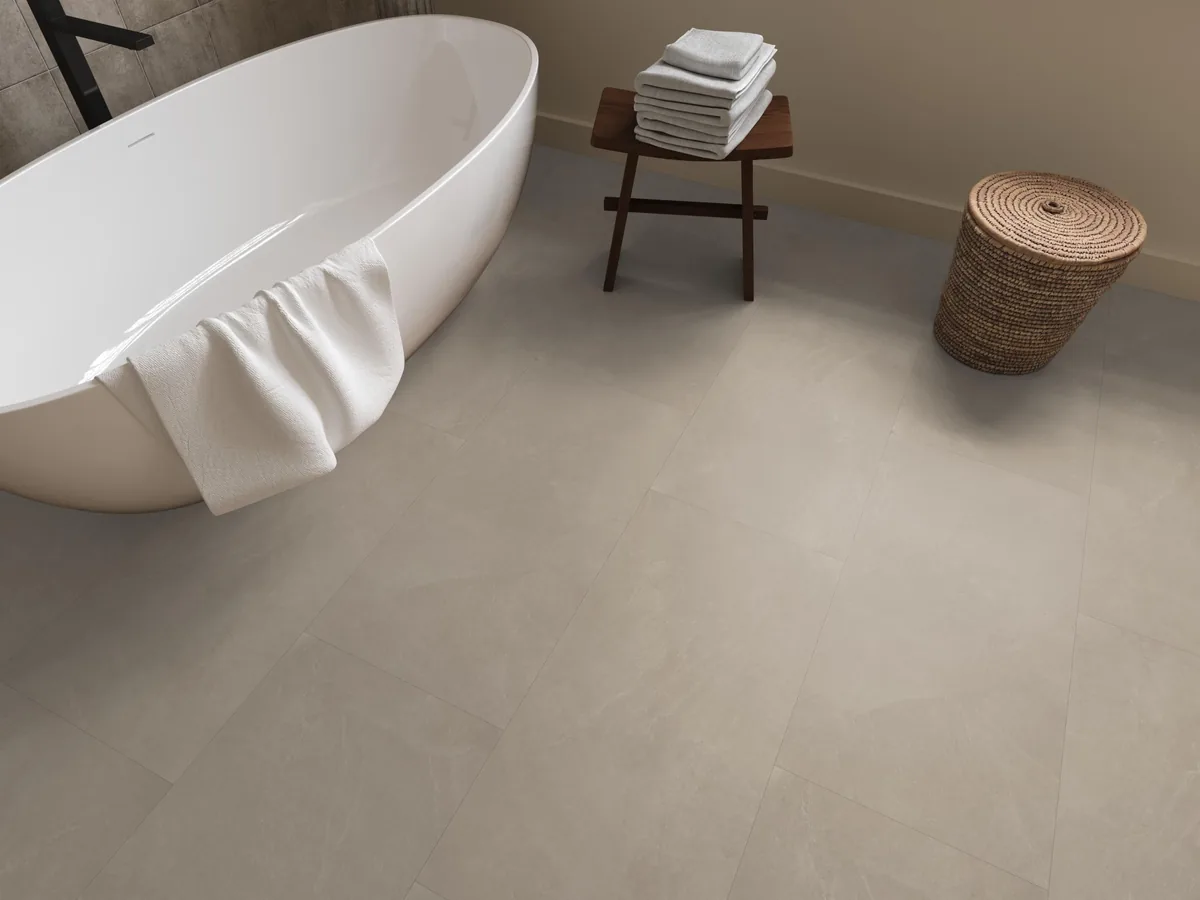 Stanmore / Noveno warm beige, plak pvc in een badkamer, met een vrijstaand bad en een rieten wasmand
