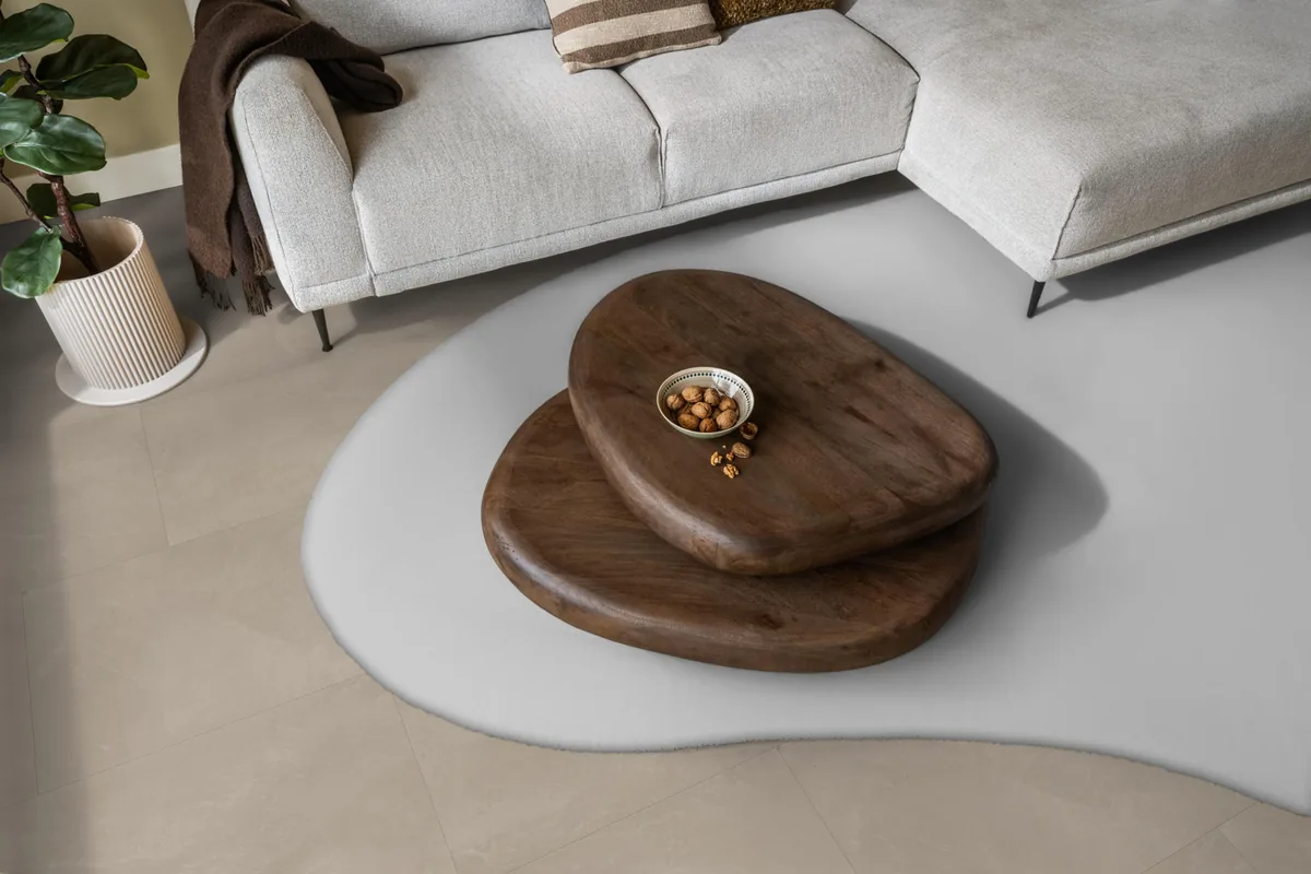 Stanmore / Noveno warm beige, plak pvc in een woonkamer, met een lichte hoekbank en een wit vloerkleed