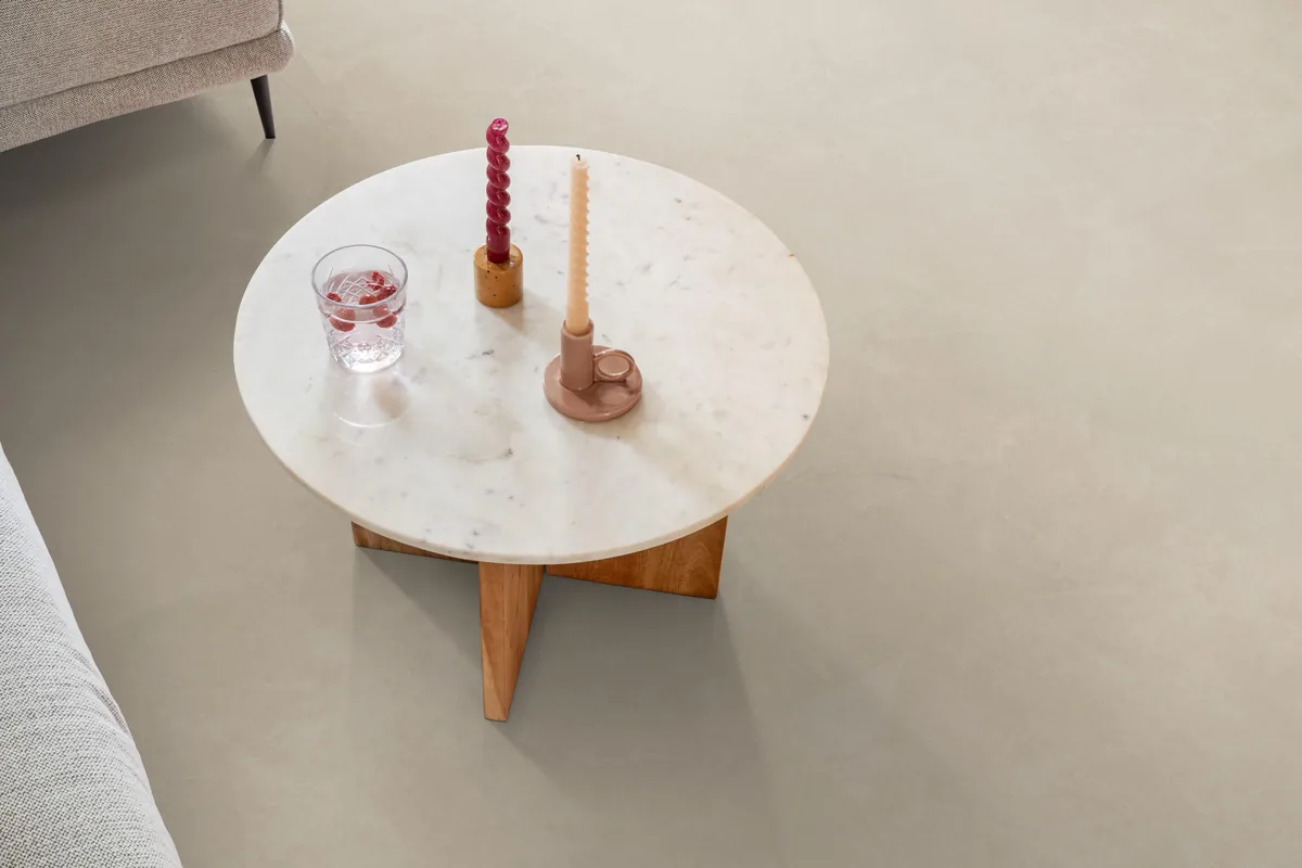 Stanmore / Noveno beige, plak pvc in een woonkamer, met een ronde marmeren salontafel en twee kaarsen