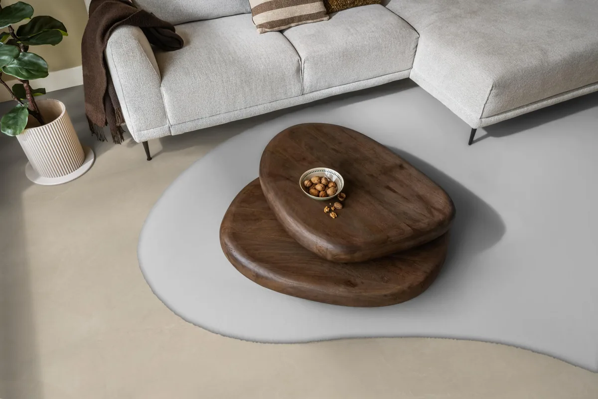 Stanmore / Noveno beige, plak pvc in een woonkamer, met een lichte hoekbank en een wit vloerkleed