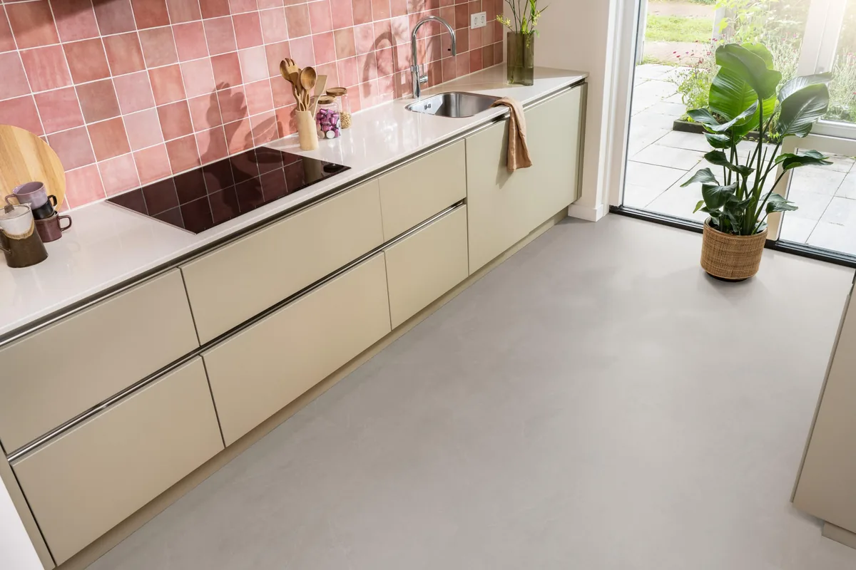 Stanmore / Noveno warm grey, klik pvc in een keuken met een roze tegelwand en openslaande tuindeuren