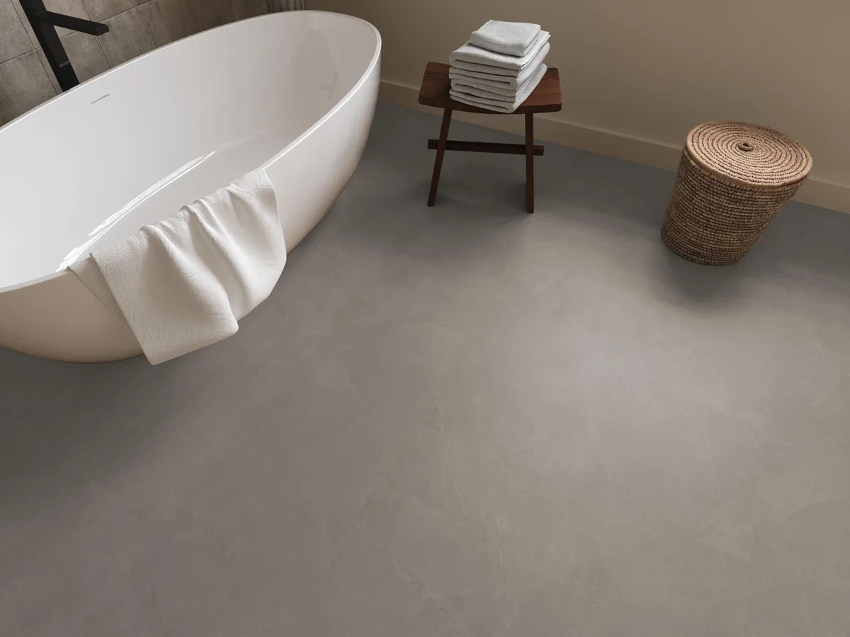 Stanmore / Noveno warm grey, klik pvc in een badkamer, met een vrijstaand bad en een rieten wasmand