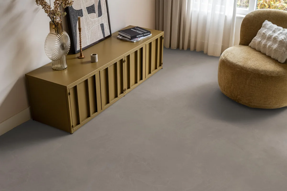 Stanmore / Noveno warm grey, klik pvc in een woonkamer, met een okergeel dressoir en een ronde fauteuil