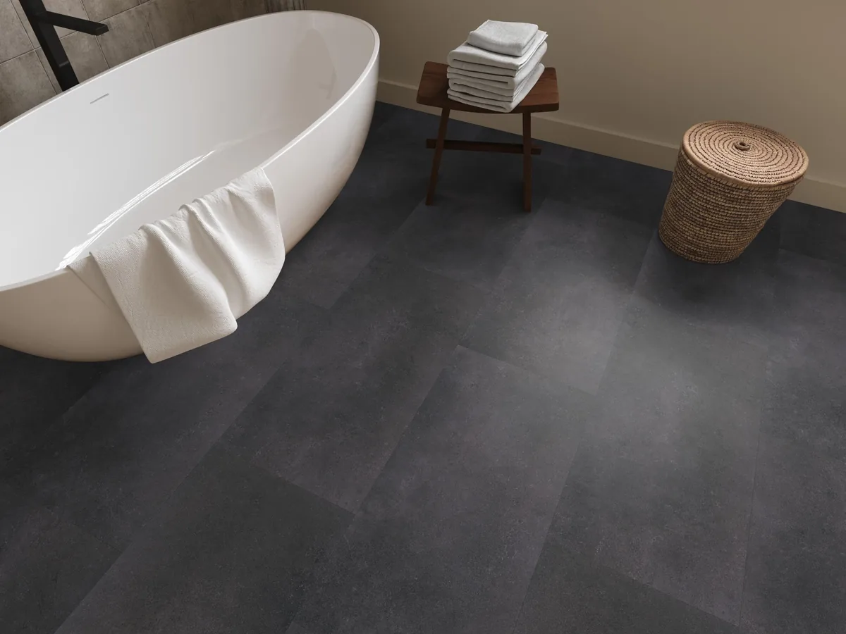 Southwark / Sarino anthracite, plak pvc in een badkamer, met een vrijstaand bad en een rieten wasmand