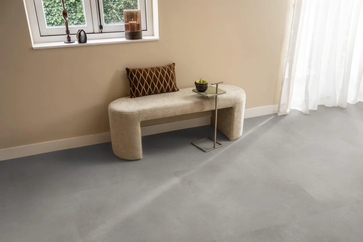 Southwark / Sarino grey, plak pvc in een hal, met een bankje onder het raam en zonlicht over de vloer