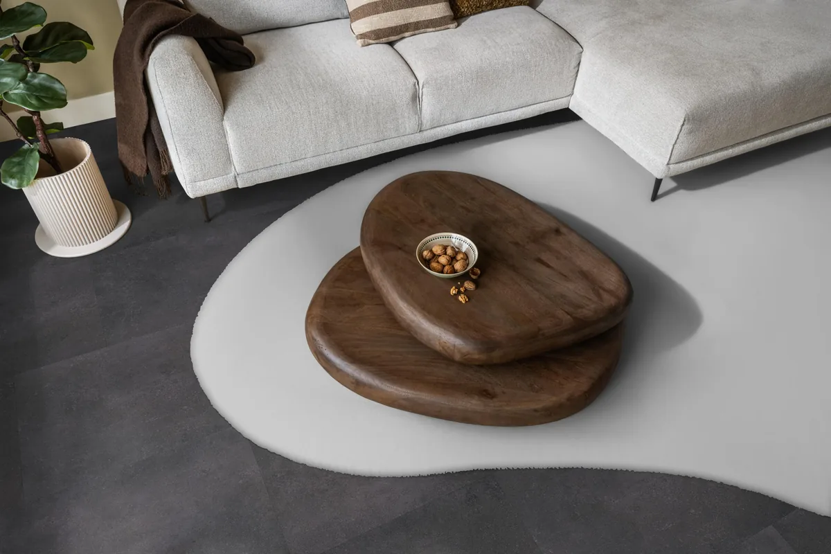Southwark / Sarino anthracite, klik pvc in een woonkamer, met een lichte hoekbank en een wit vloerkleed
