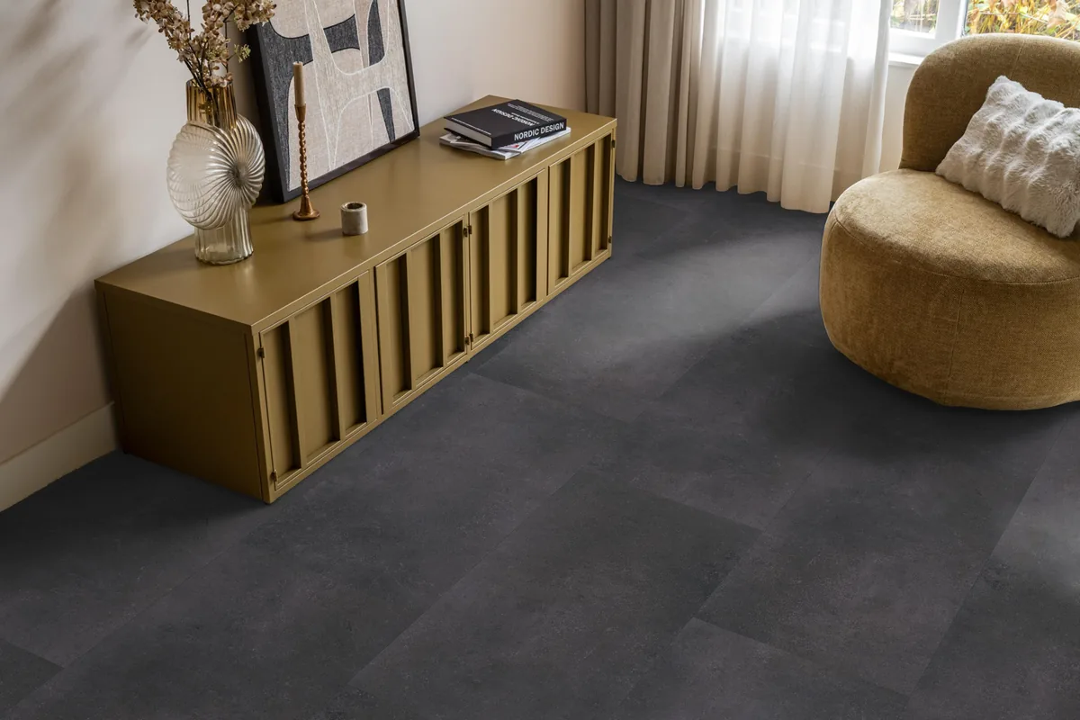 Southwark / Sarino anthracite, klik pvc in een woonkamer, met een okergeel dressoir en een ronde fauteuil