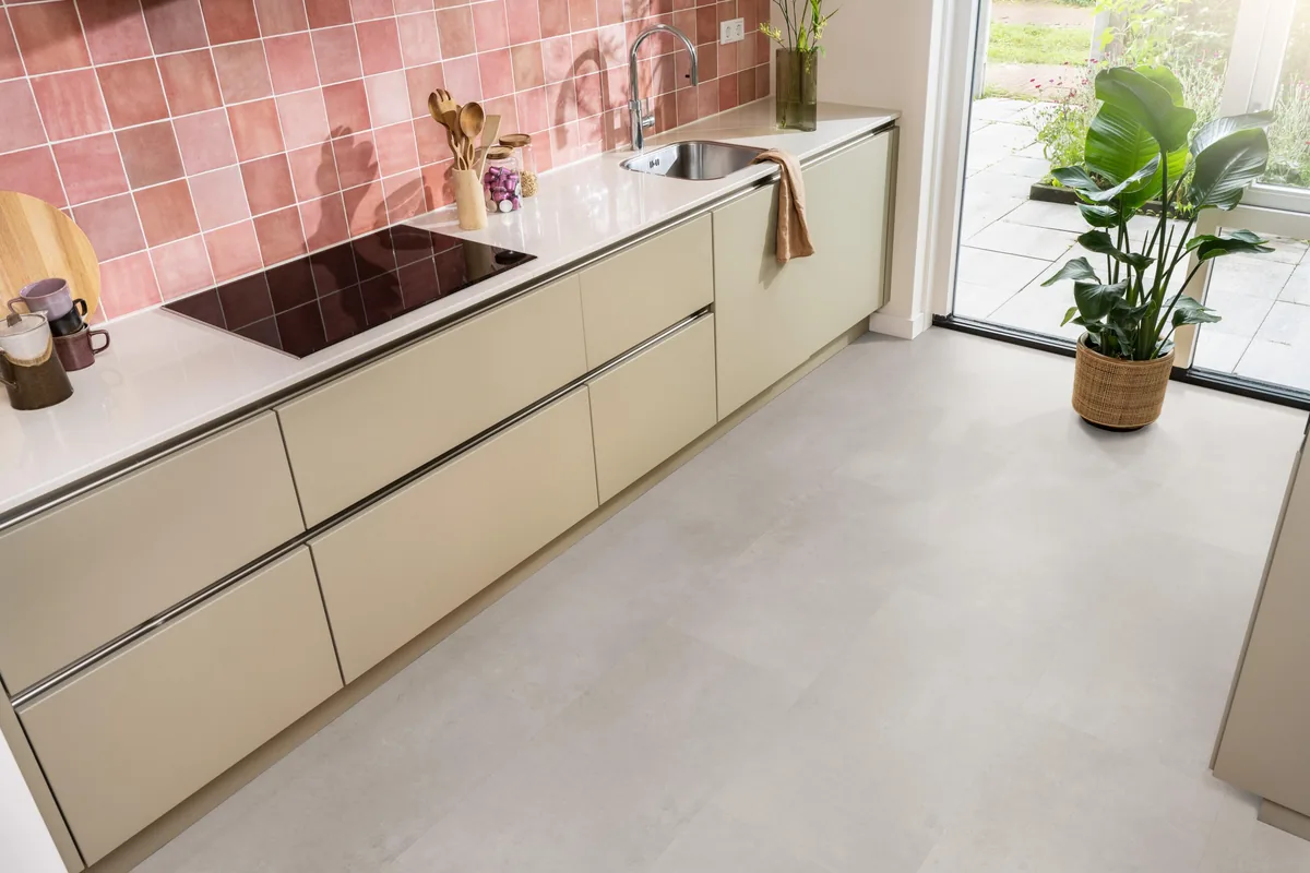 Southwark / Sarino light grey, klik pvc in een keuken met een roze tegelwand en openslaande tuindeuren