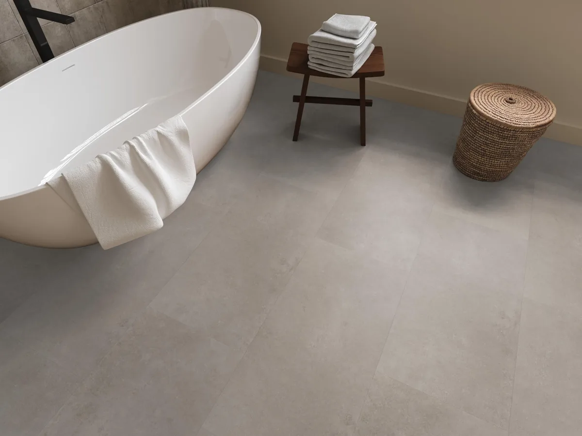 Southwark / Sarino light grey, klik pvc in een badkamer, met een vrijstaand bad en een rieten wasmand
