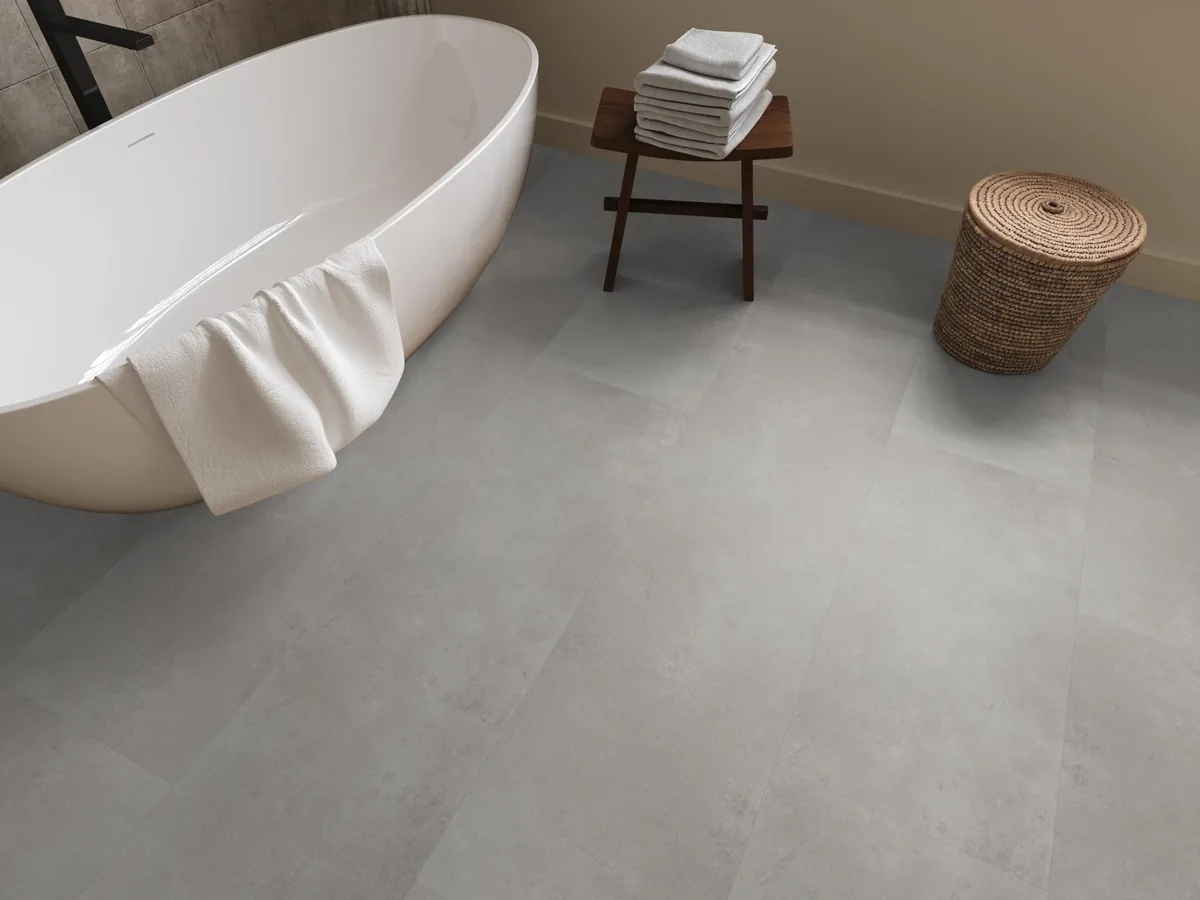 Southwark / Sarino grey, klik pvc in een badkamer, met een vrijstaand bad en een rieten wasmand